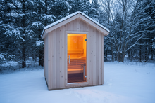 Load image into Gallery viewer, Hand-crafted white cedar sauna shed with A-frame gable roof and full-length tempered glass door, warm interior glow, Ontario backyard setting
